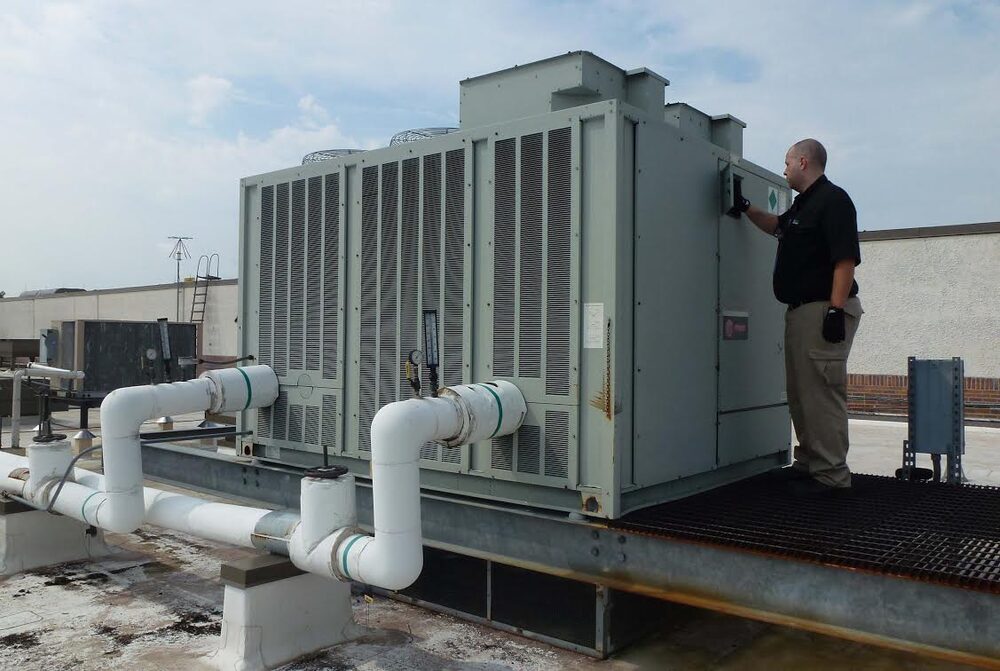 Strategic Filtration technician inspecting a rooftop cooling tower